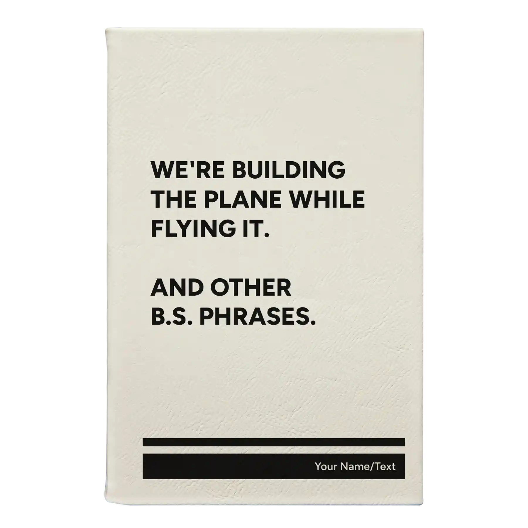 Small white leatherette journal laser etched with 'We're Building The Plane While Flying It. And Other B.S. Phrases' design