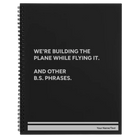 Large black spiral notebook laser etched with 'We're Building The Plane While Flying It. And Other B.S. Phrases' design
