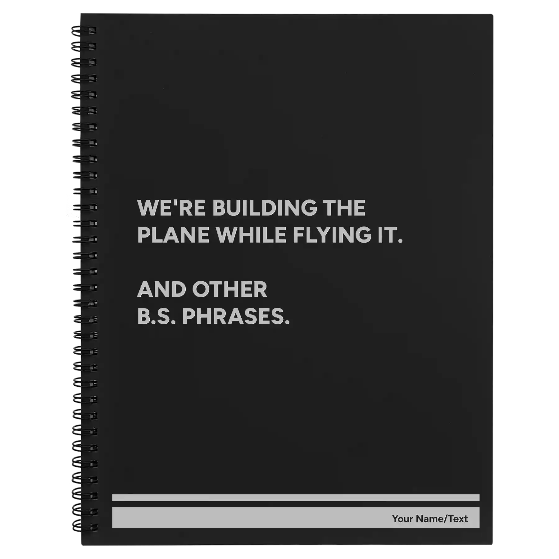 Large black spiral notebook laser etched with 'We're Building The Plane While Flying It. And Other B.S. Phrases' design