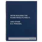 Large blue spiral notebook laser etched with 'We're Building The Plane While Flying It. And Other B.S. Phrases' design