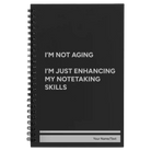 Small black spiral notebook laser etched with 'Not Aging' design