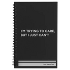 Small black spiral notebook laser etched with 'Trying to Care' design