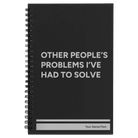 Small black spiral notebook laser etched with 'Other Peoples Problems' design