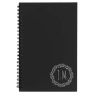 Small black spiral notebook laser etched with 'Wreath Initials' design